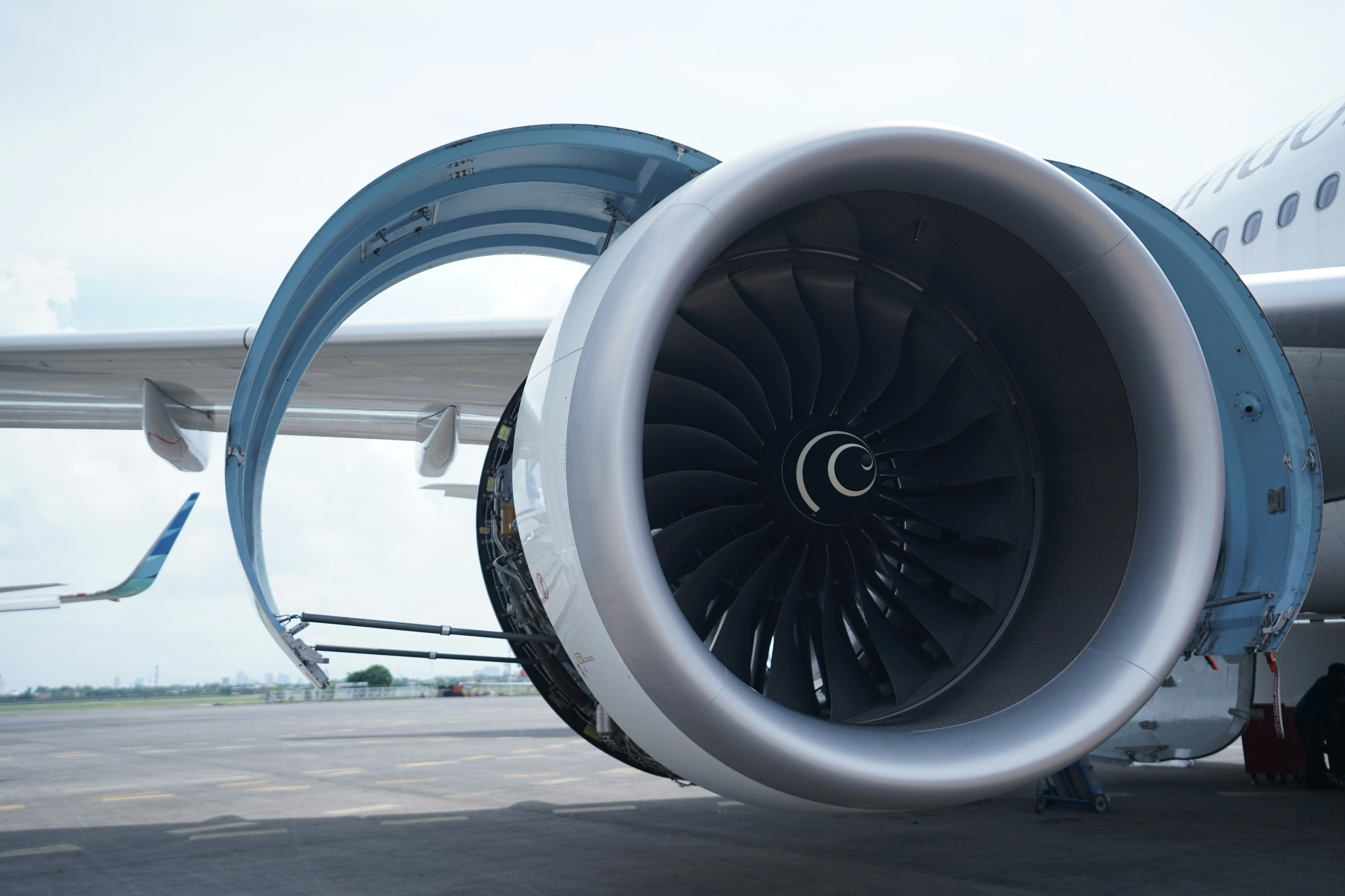 Close-up of an aircraft engine with the cowl open on the tarmac